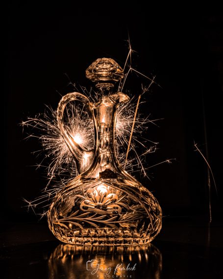 Glänzender Glasbehälter mit hellen Lichtern und funkelnden Effekten.