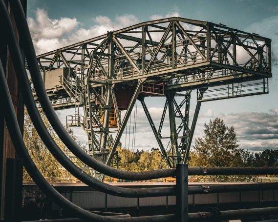 Industrielle Struktur mit Kransystem und klarer Landschaft im Hintergrund.